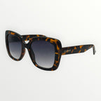 Sunglasses with tortoiseshell frame and gradient lenses on a white background