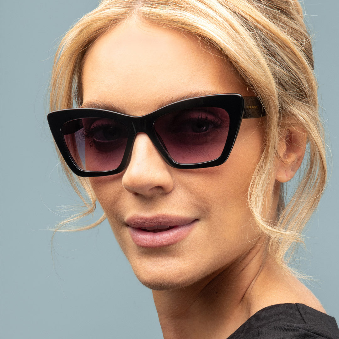 Woman wearing black sunglasses with a neutral background