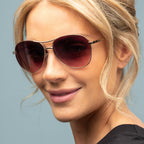 Close-up of a woman wearing sunglasses with a plain background