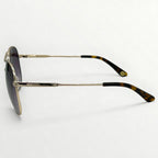 Sunglasses with gold frame and tortoiseshell accents on a white background