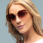 Woman wearing sunglasses with a neutral background