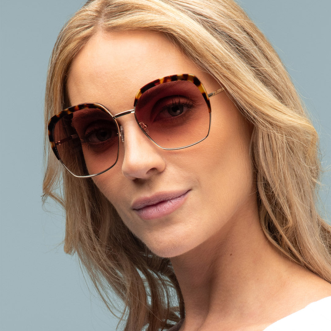 Woman wearing sunglasses with a neutral background