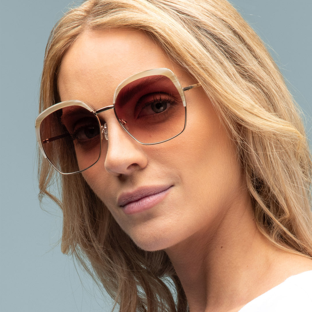 Woman wearing sunglasses with a neutral background