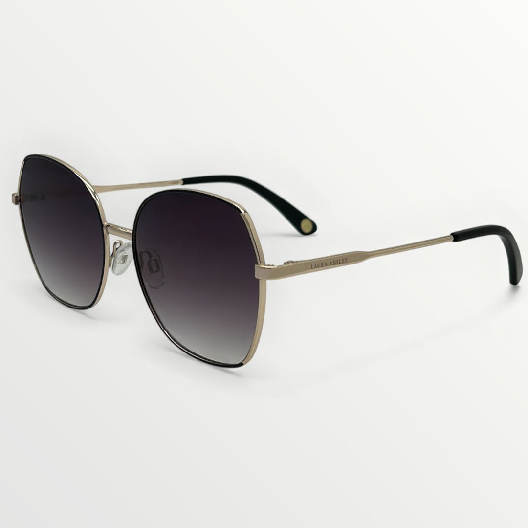 Sunglasses with gold frame and black gradient lenses on a white background
