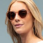 Woman wearing sunglasses with a plain background