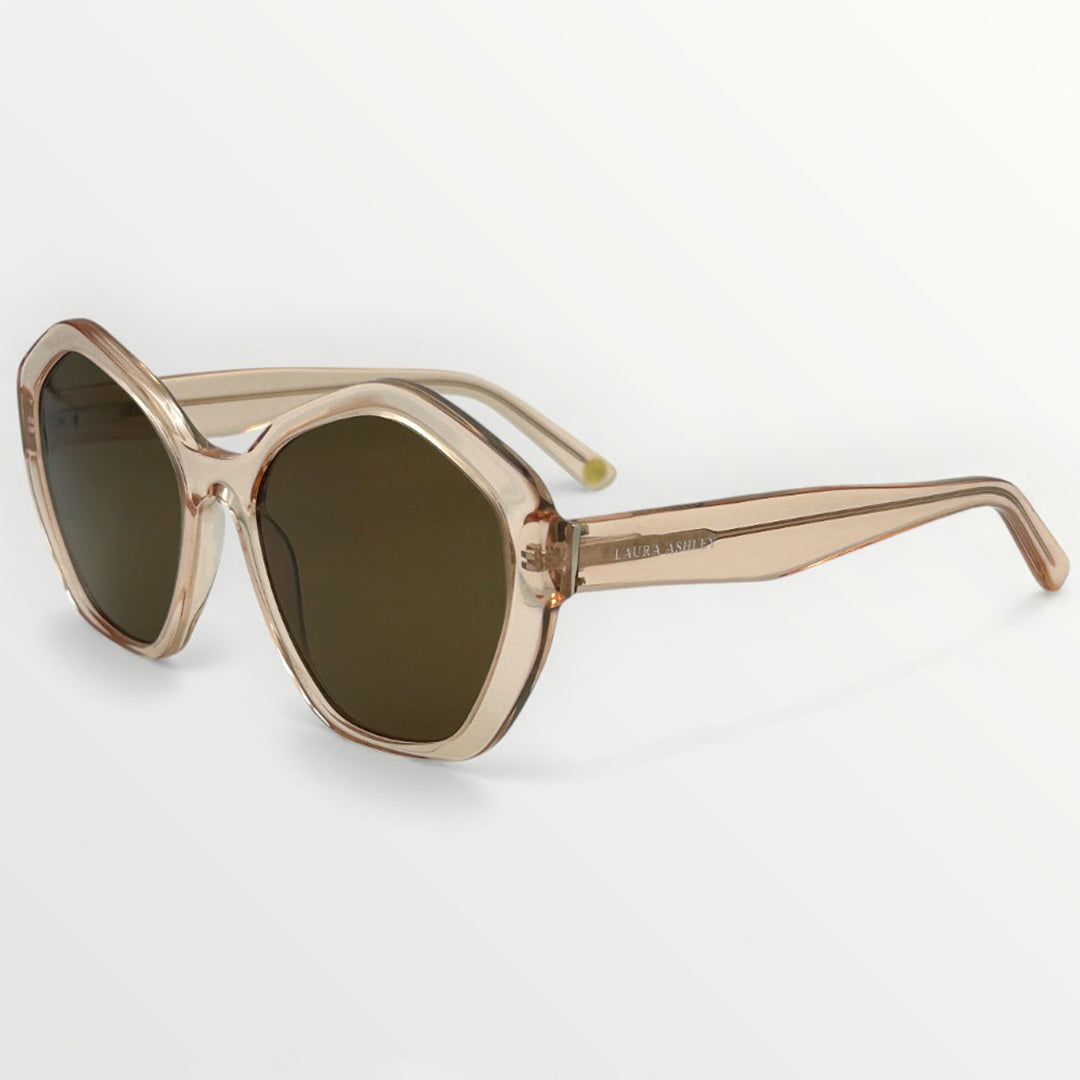 Sunglasses with gold frame and dark lenses on a light gray background