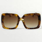 Sunglasses with tortoiseshell frame and brown gradient lenses on a white background