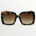 Sunglasses with tortoiseshell frame and brown gradient lenses on a white background
