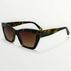 Sunglasses with tortoiseshell frame and brown gradient lenses on a white background